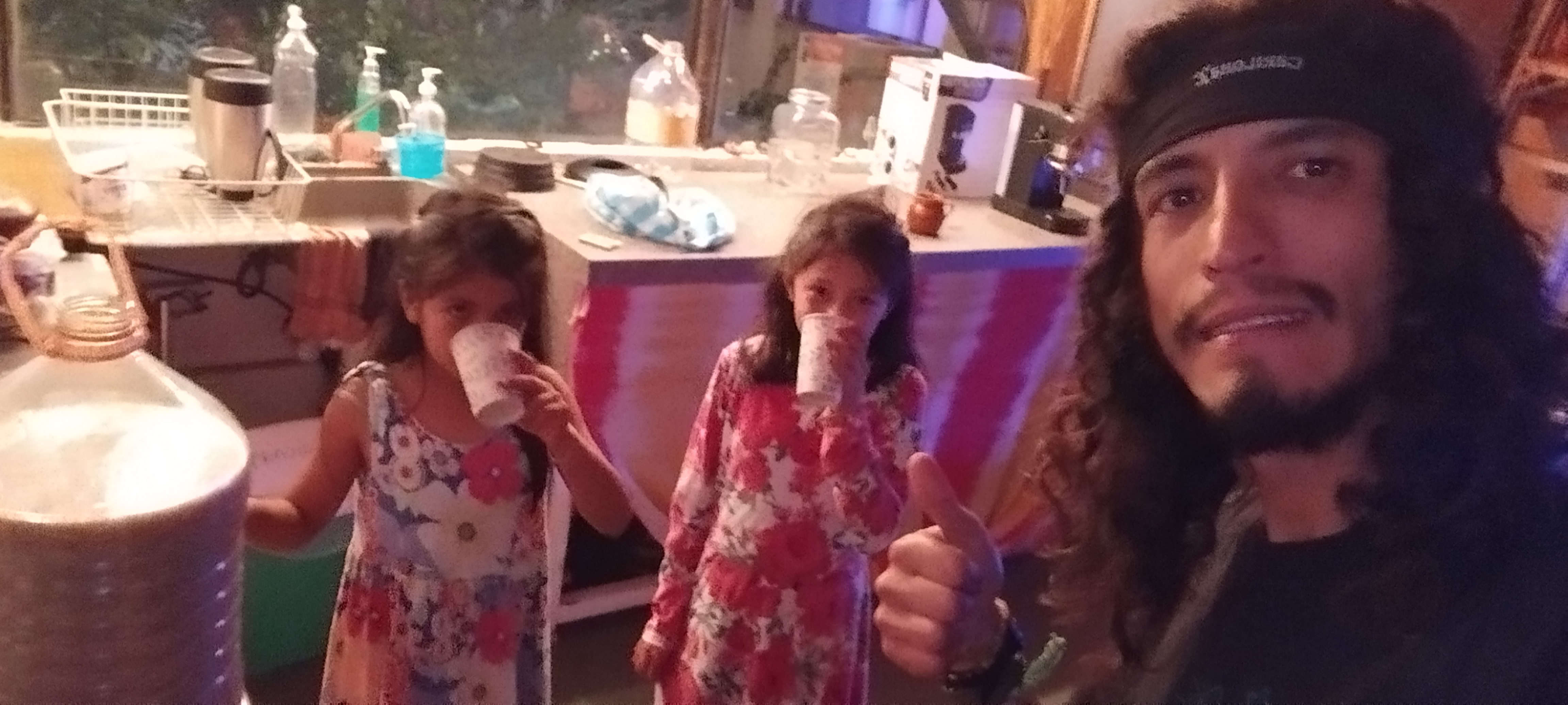 Amarantonio y dos niñas bebiendo, simbolizando la nutrición consciente para las nuevas generaciones.